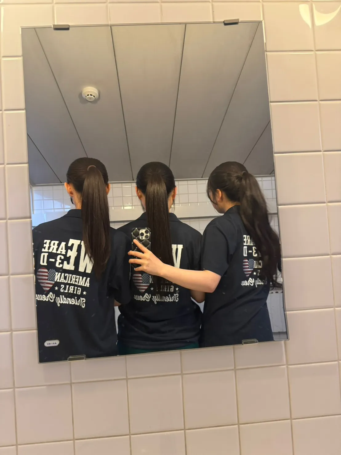 背面のWE ARE 3-Dデザインを見せた鏡越しショット