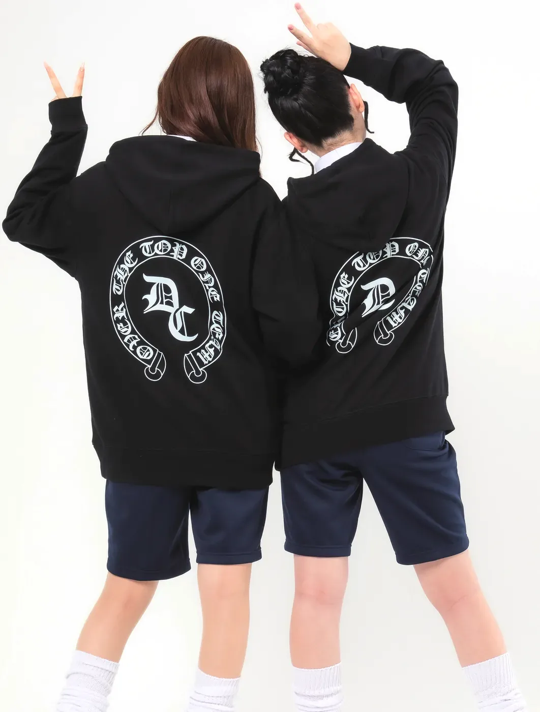 ブラックのイベントパーカーの背面にサークルロゴ(D-742)を白で大きくプリント。2人の女子高生の背面