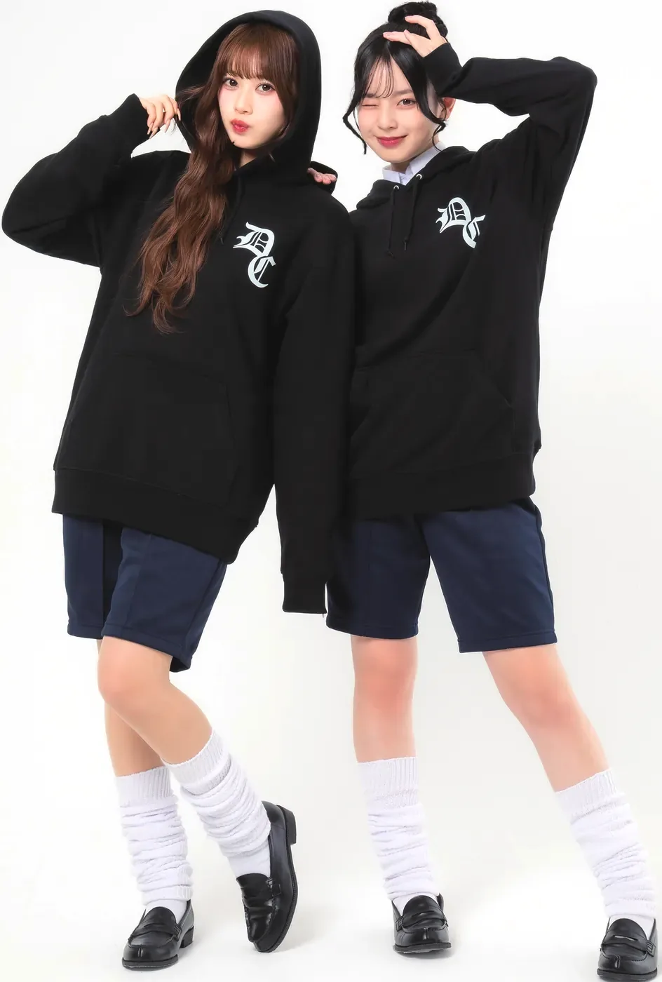 ブラックのイベントパーカーの左胸にサークルロゴ(D-742)の中央文字をワンポイントで白プリント。2人の女子高生の前面